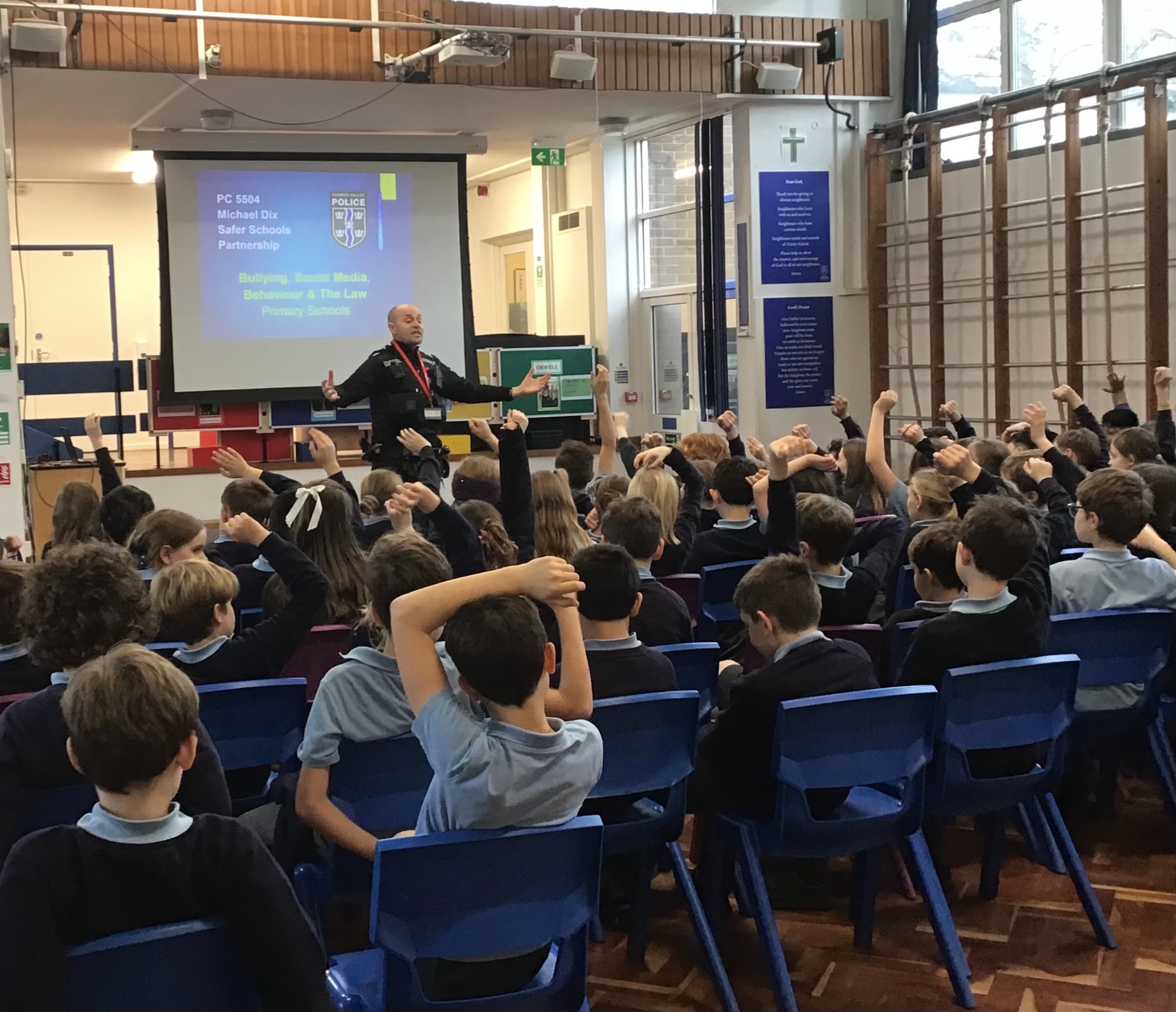 Policeman talking to pupils in the hall photo